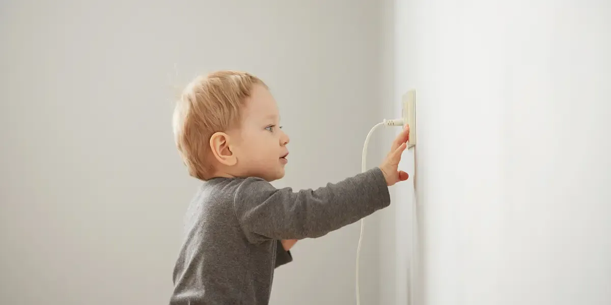 Curious child playing with electrical outlet